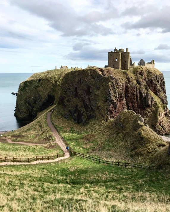 a castle atop a small rocky outcrop on an ocean