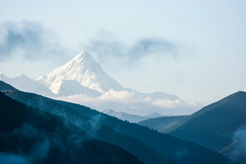 the mountain with fog is covered by the clouds