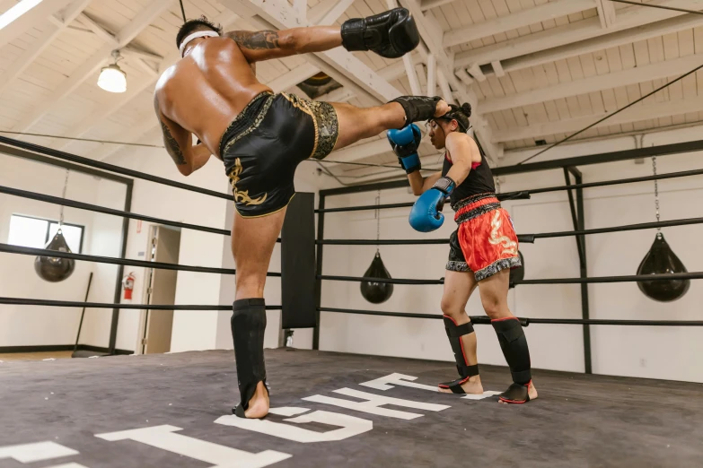 a male in an orange trunks is performing a kick