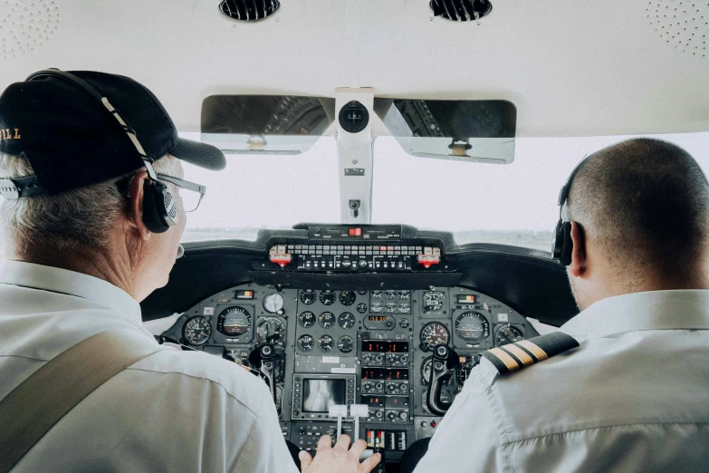 two pilots looking out the cockpit of a small plane