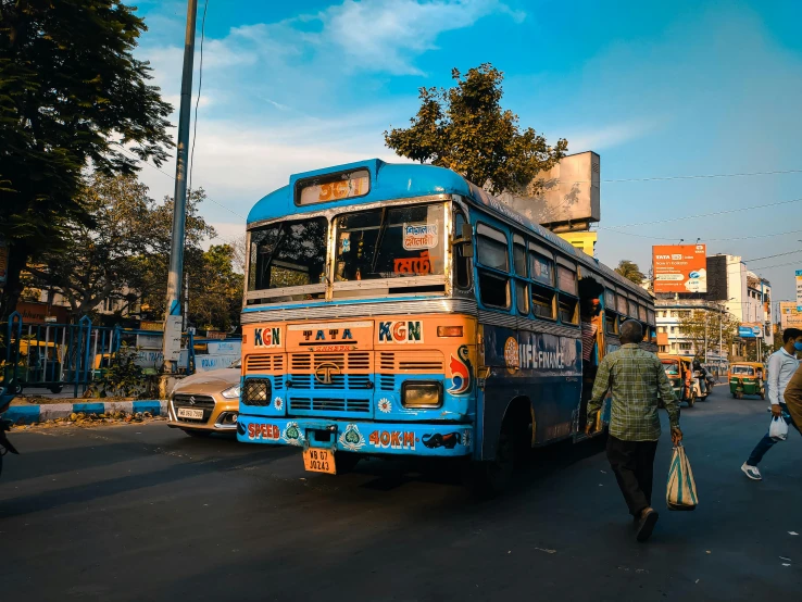 people walking on a sidewalk next to a bus