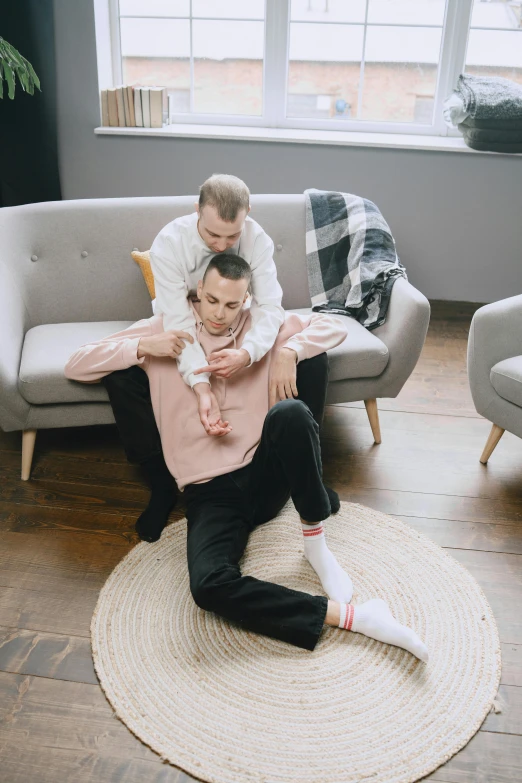 two people sitting on top of each other in a living room