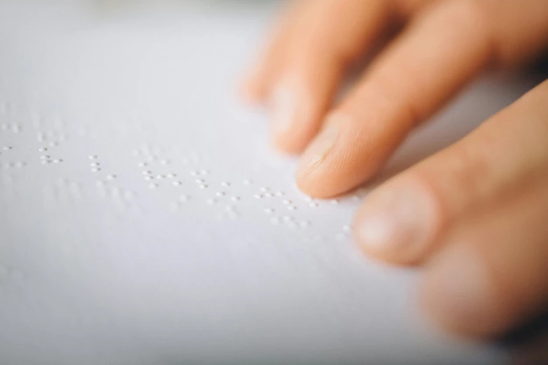 the image shows a person's hands holding soing on top of a white sheet