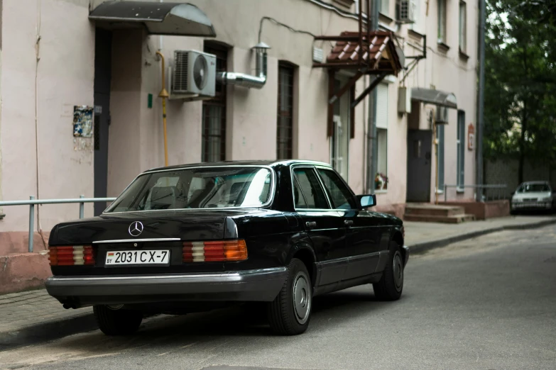 a car parked along side a tall building