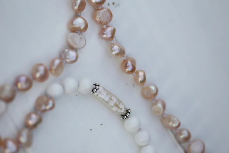 a close up of a long necklace with pearls on it