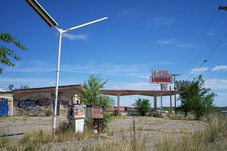 a sign is shown in the foreground with a gas station in the background