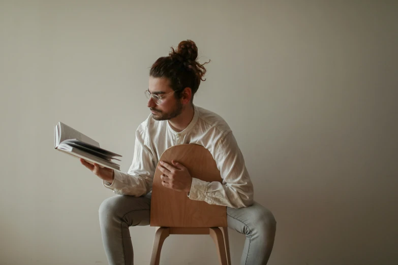 a person sitting on a chair holding a book