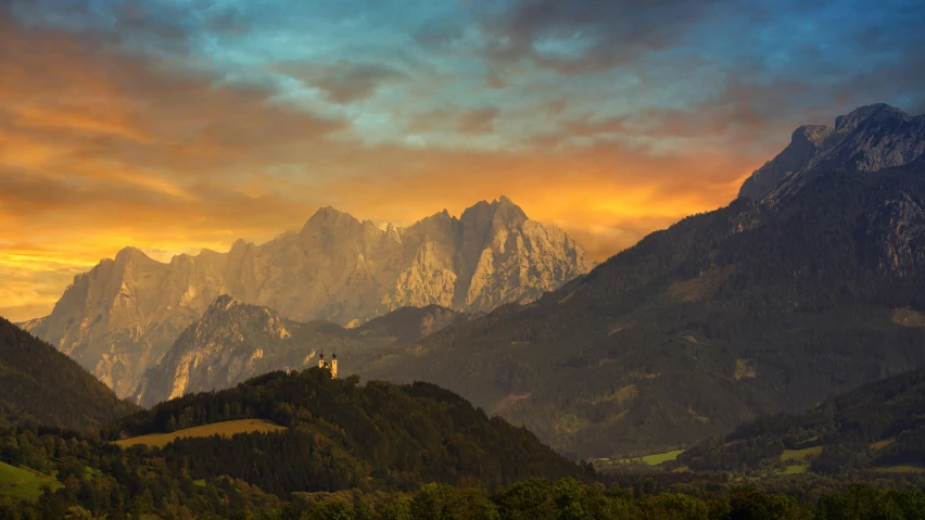 a scenic scene of a mountain range with a building in the foreground