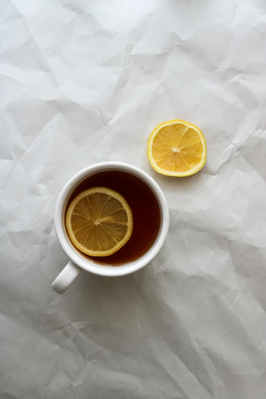 a cup of tea with a lemon slice on it