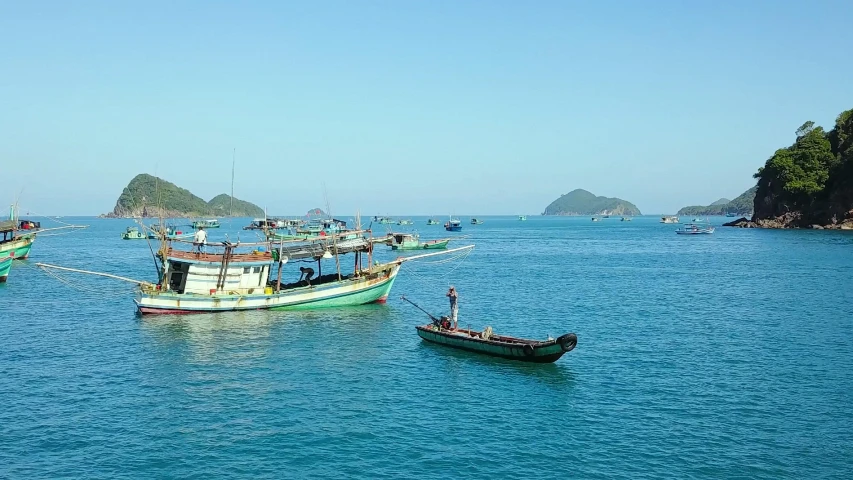 several boats are out on the water with a few rocks