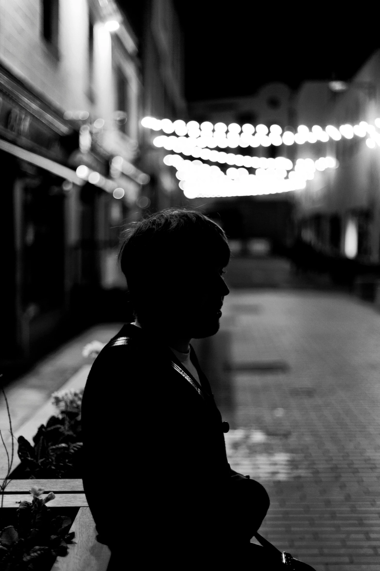 a person sitting on the street near a building