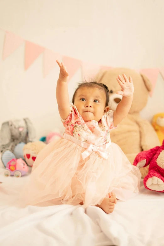 a baby girl in her tutu on top of a bed