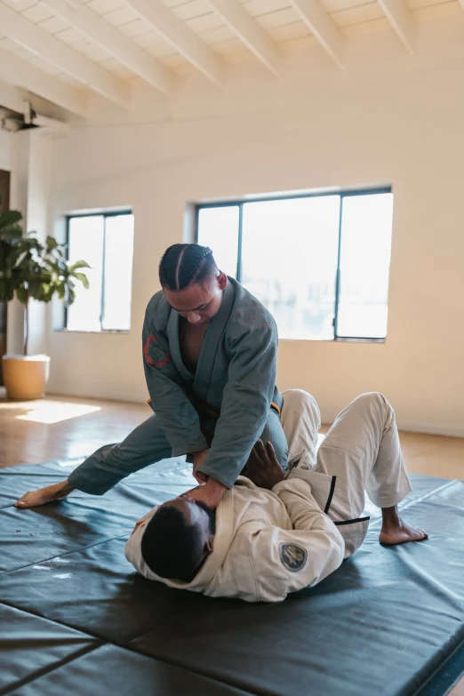 two men one in a white uniform and the other in a black suit are doing an exercise