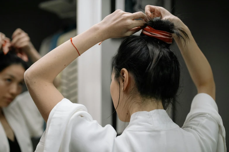 two women combing each other's hair in a room