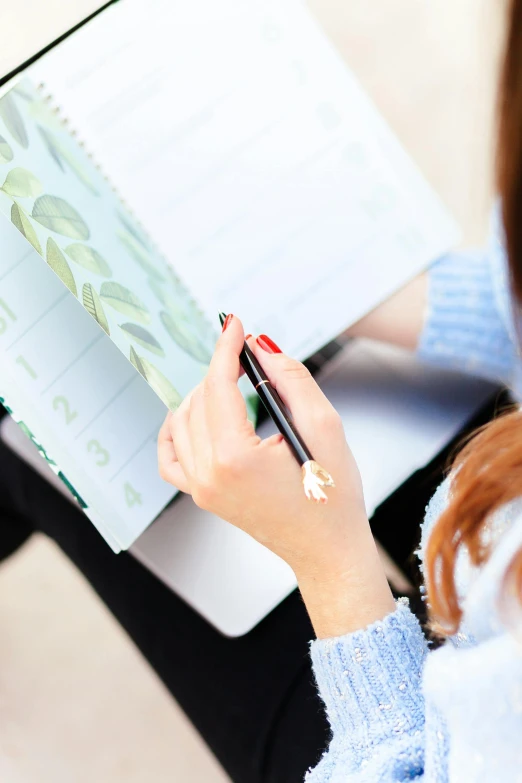 woman writing on a spiral notepad at a table