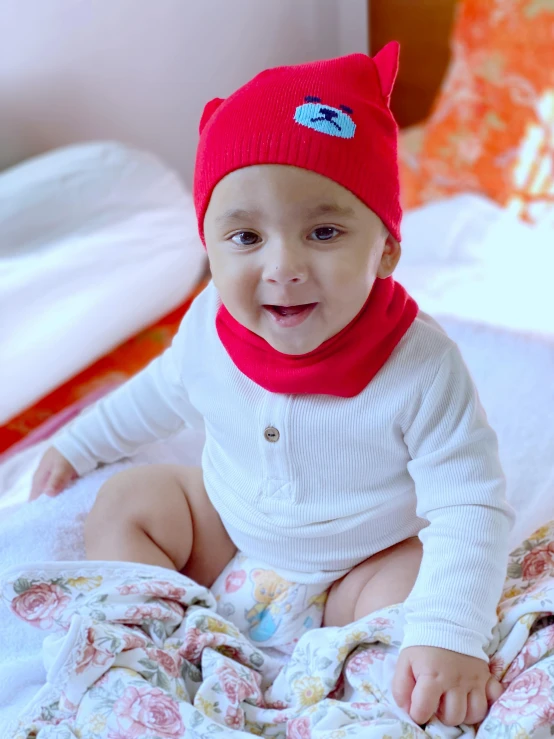 a baby wearing a red hat and sweater