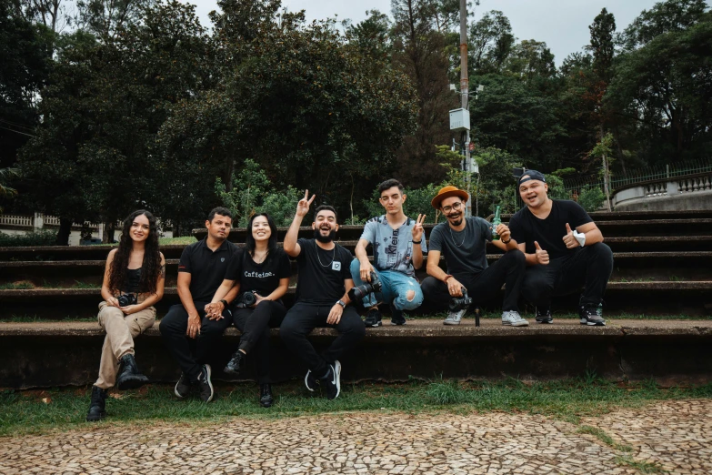 the group of young people are sitting on the steps