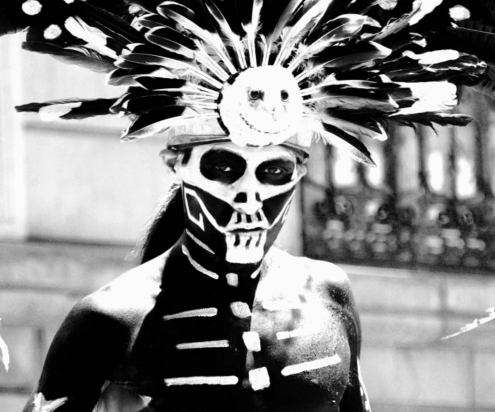 a skeleton in costume with feathers on its head