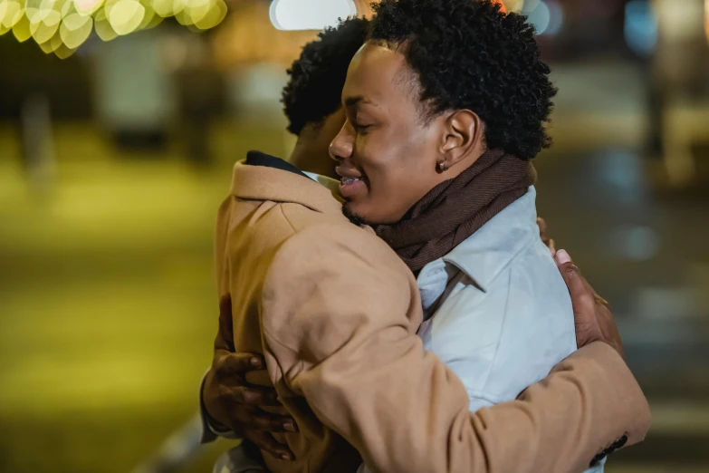 a couple of people standing near each other hugging