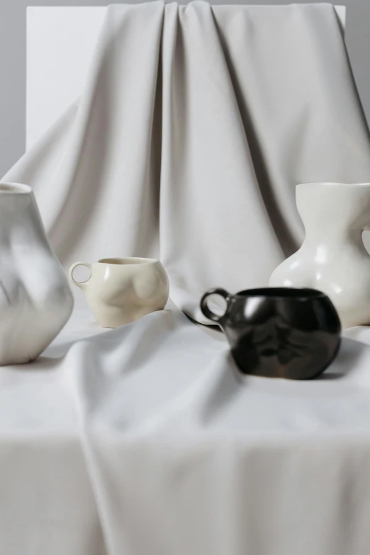 a row of vases sit atop the fabric covered table