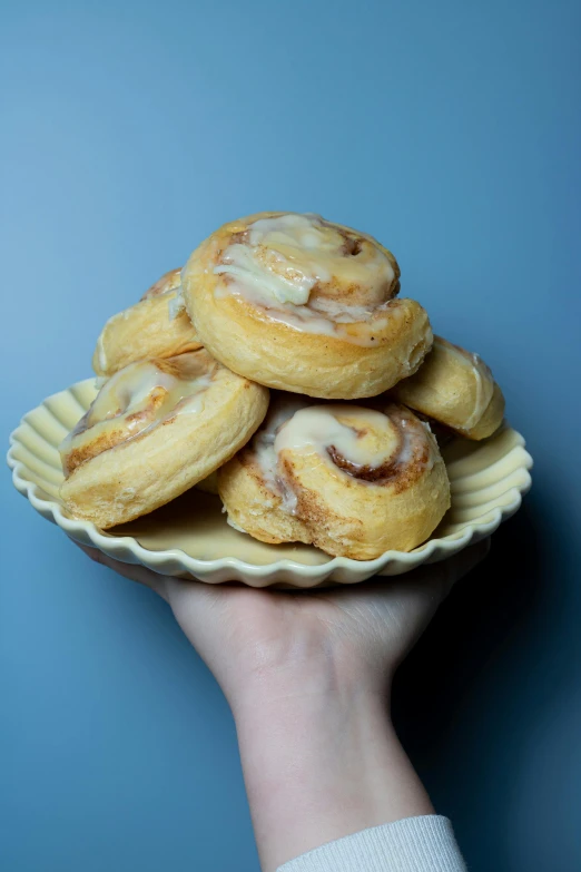 a person holding a plate with mini pastries on it