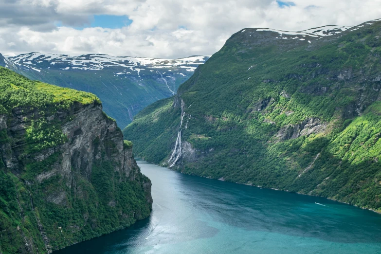 a mountain side area is shown with blue water