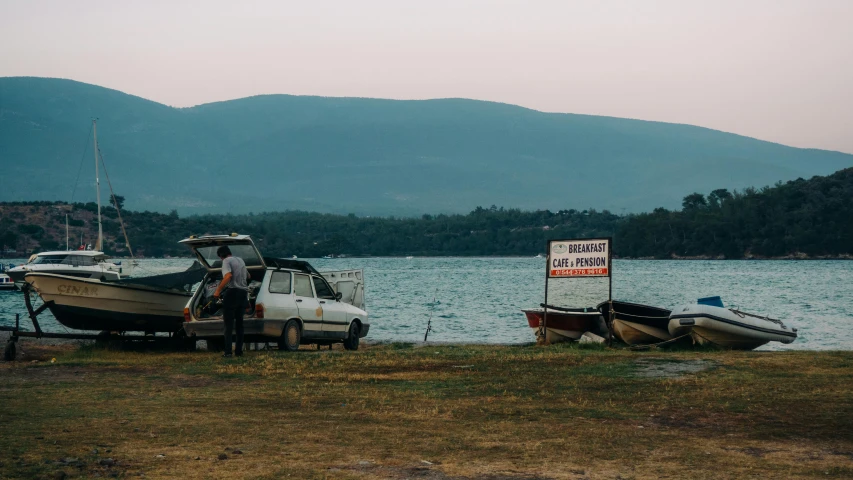 two small boats docked at a shore near mountains