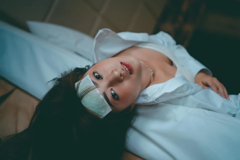 an image of a woman with bandages on her head laying down