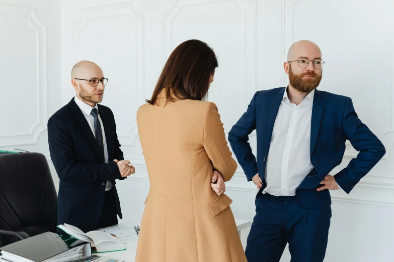 two men and a woman in a white room