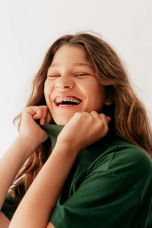 a smiling girl wearing a green top