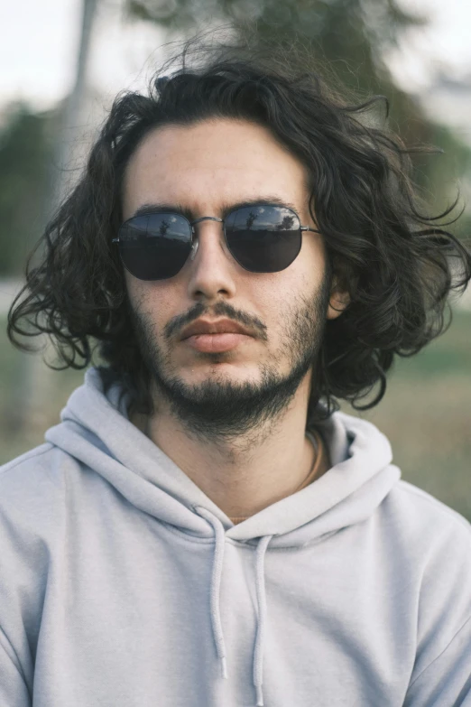 man wearing sunglasses standing in a park