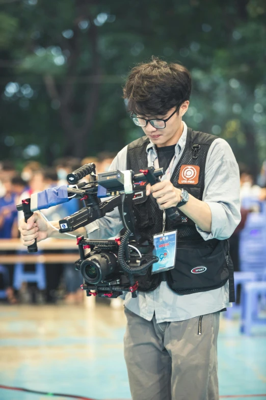 a man holding an electronic camera near a crowd