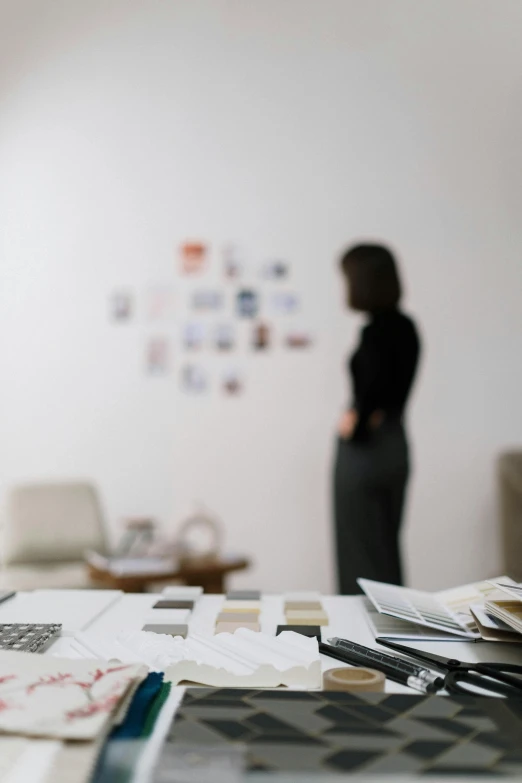 woman standing in room with papers on table next to chair