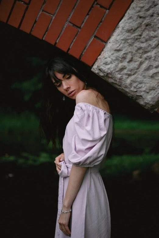 a woman in a long white dress with an umbrella