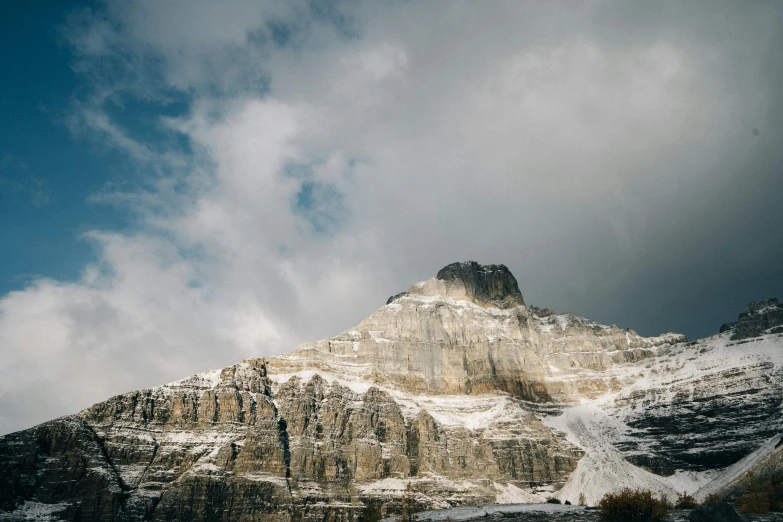 a mountain in the middle of winter under cloudy skies