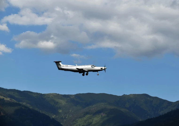 a passenger jet flying over a valley and mountains