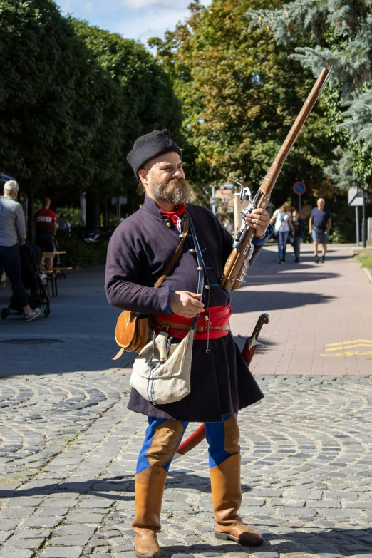 a man dressed in traditional attire holding a gun