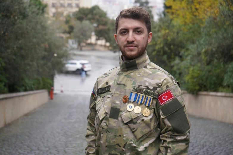 man in uniform stands on the walkway near the water