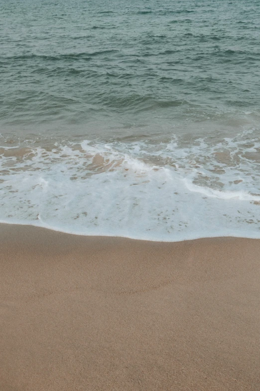 a person standing on top of the beach in front of the ocean