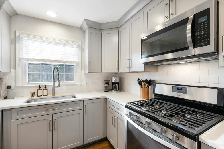 a stove top oven sitting under a microwave oven