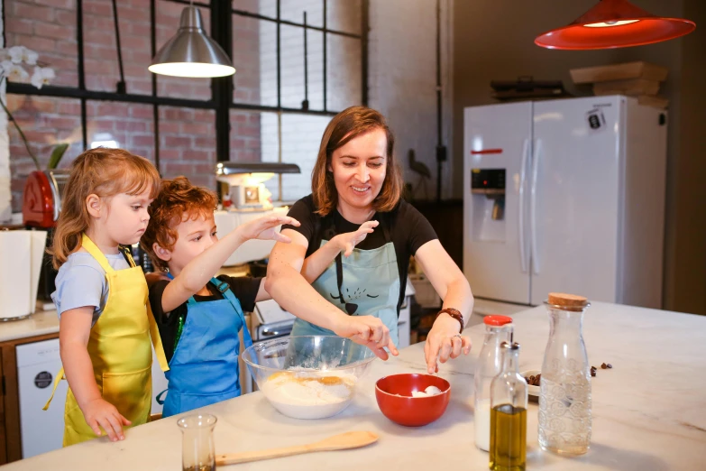 two children in the kitchen helping an older woman mix the ingredients