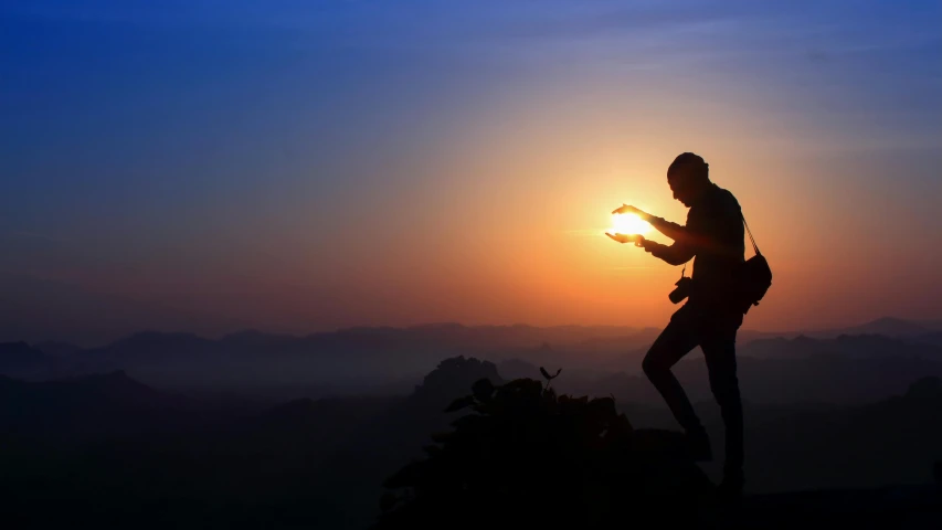 a woman with a cell phone looking at the sun