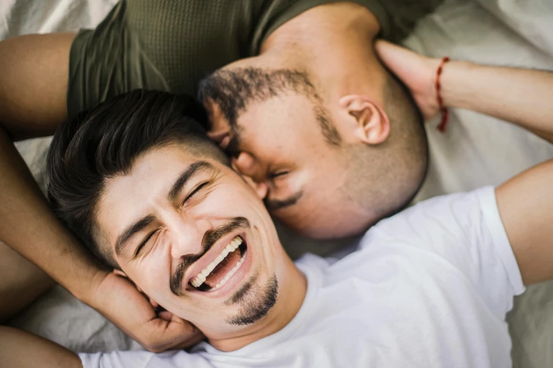 a man is laying next to a smiling man