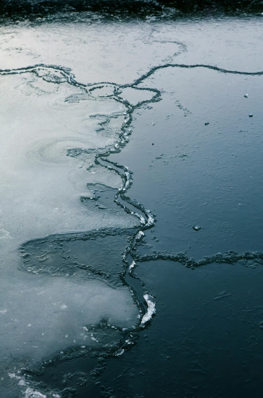 an icy river has very thin lines in the water