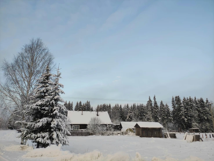 a small snowy house in the middle of the field