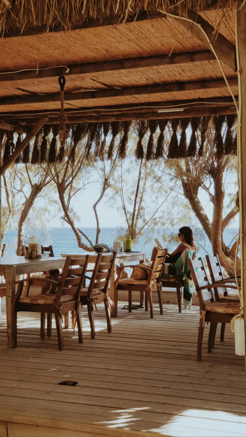 a woman sits at the end of the outdoor table