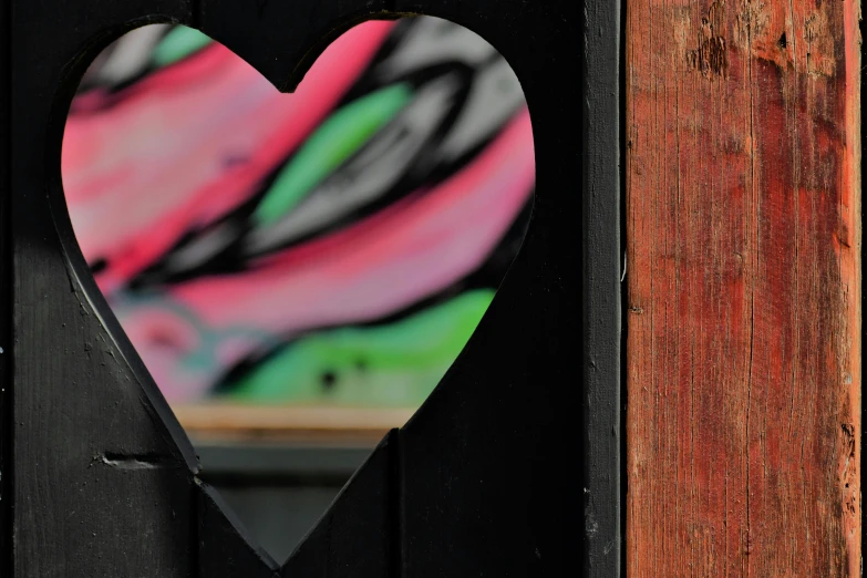 a heart shaped picture hangs on the front of a door