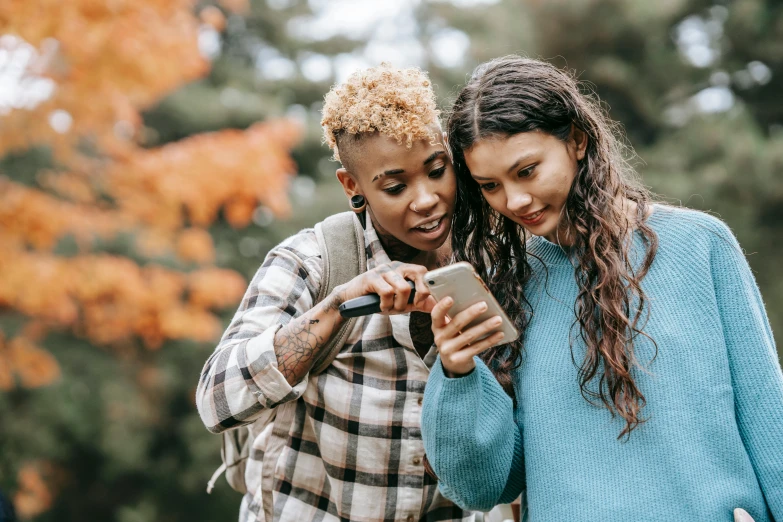 two young women looking at a cell phone