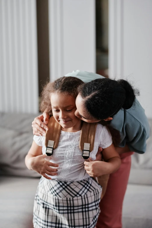 two children playing with a backpack on their back