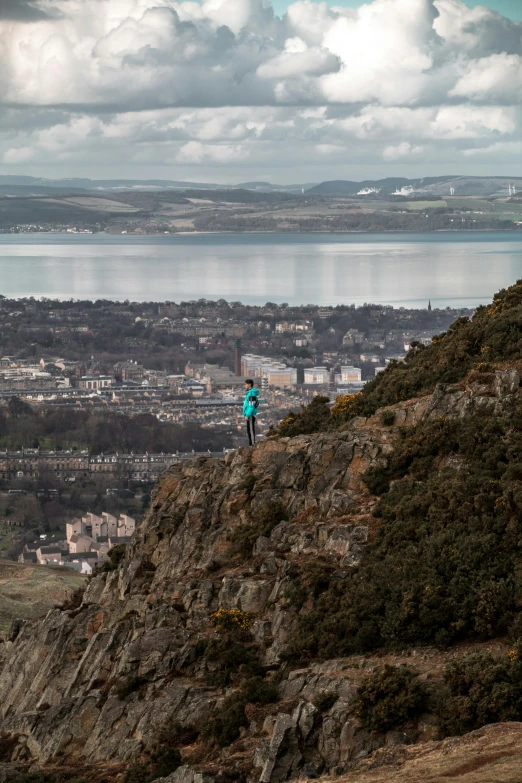 a person on a hill overlooking the water